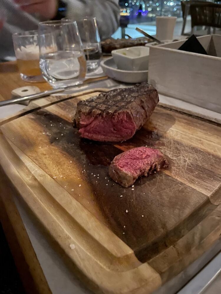 A steak on a cutting board Description automatically generated