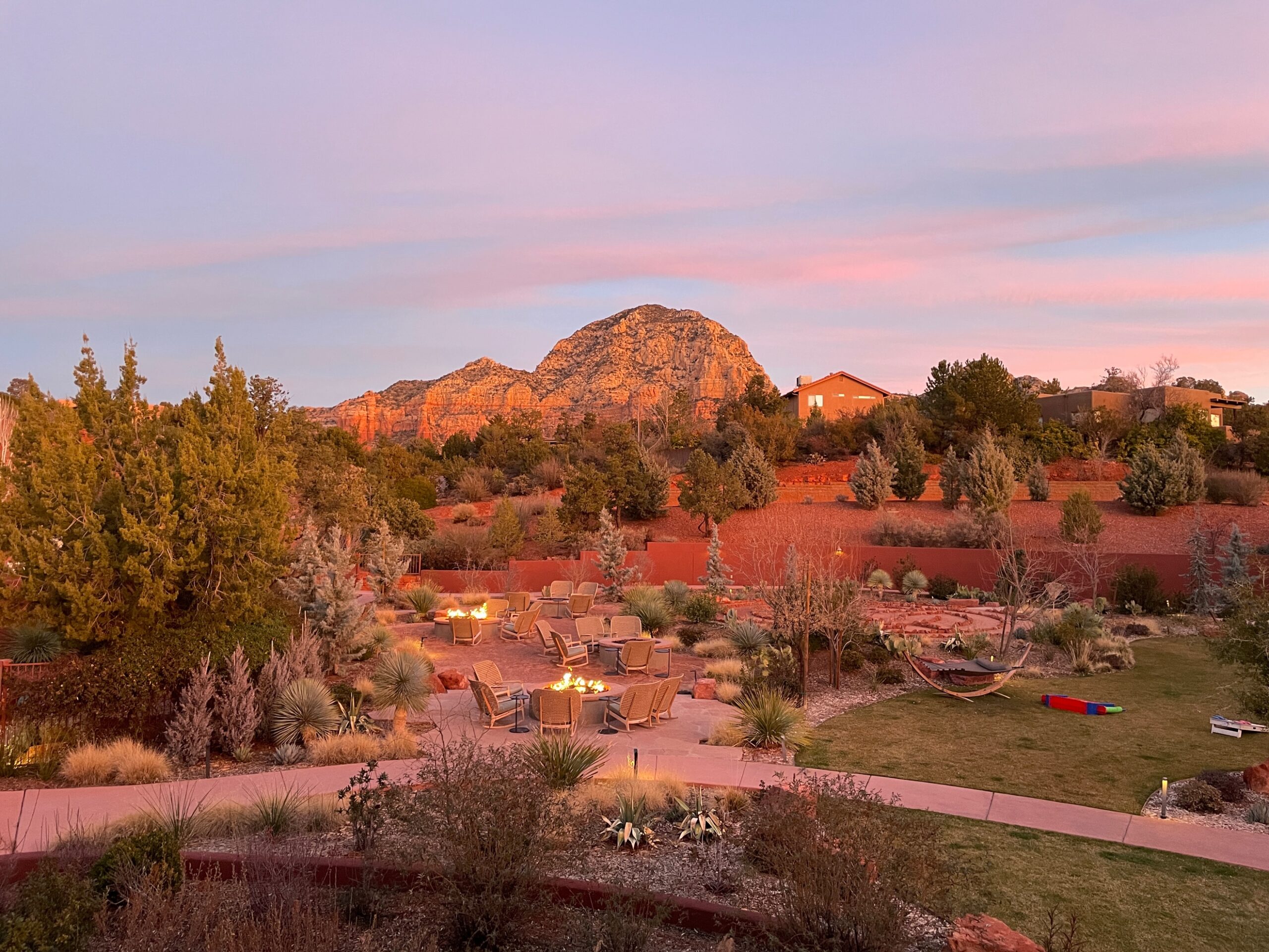 A landscape with a patio and a large rock mountain Description automatically generated with medium confidence